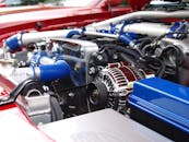 Detailed view of a clean modern car engine with vibrant colored components and sleek design.